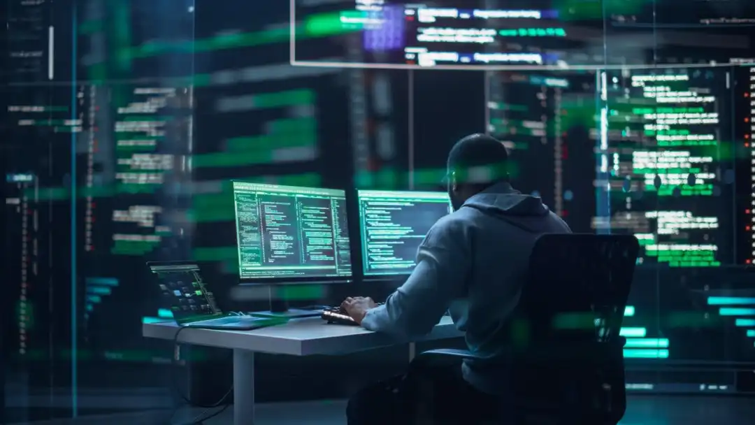 programmer writes software code on background of screens
