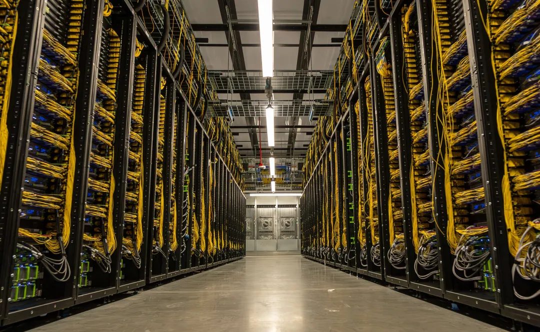 Meta Prometheus supercluster cold aisle in New Albany, Ohio, with racks of yellow fiber cabling on both sides