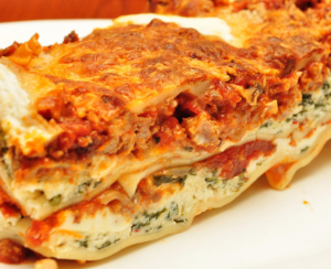 A slice of lasagna on a plate.