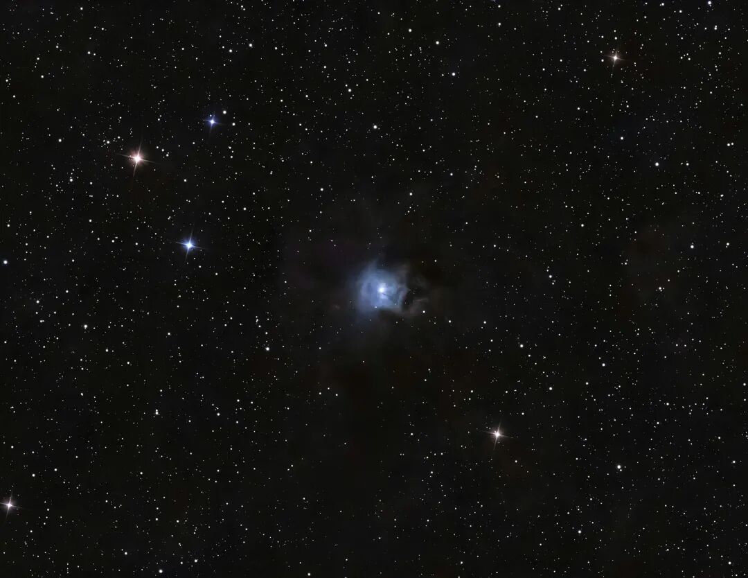 A blue nebula surrounded by countless stars in deep space.