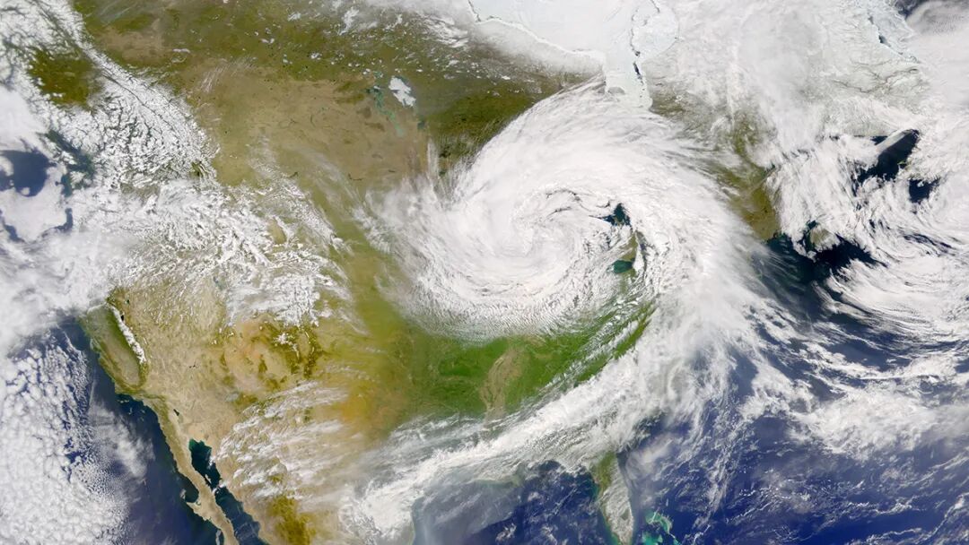 A satellite image shows a mass of swirling white clouds hanging over the central United States.